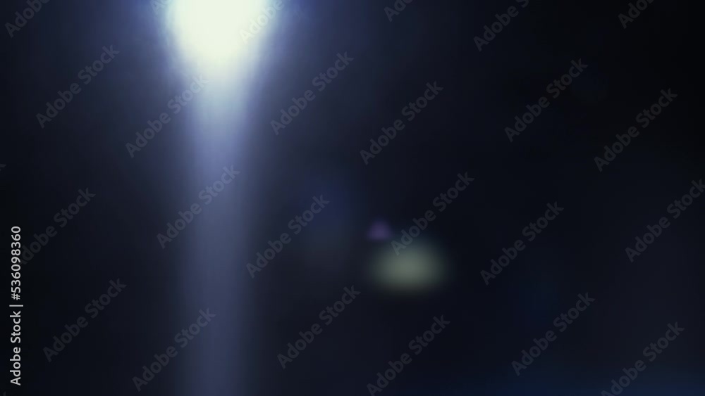 Real lens flare. Sun motion effect. Moving light circle and beams on dark background Real lens flare. Sun motion effect. Moving light circle and beams on dark background