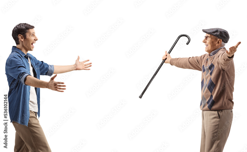 Happy young man walking towards an elderly man with arms wide open Happy young man walking towards an elderly man with arms wide open