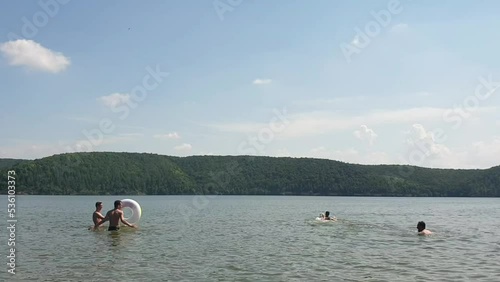 father with children playing in the river, swimming and outdoor activities in summer