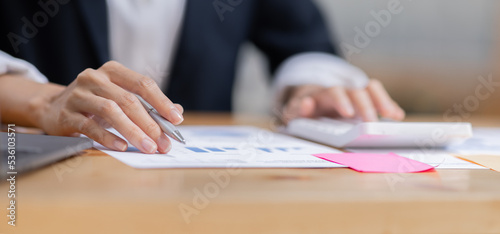 Cheerful female businesswoman entrepreneur professional working on laptop while sitting in workplace office desk, business asian woman do Documents, tax, report analysis Savings, finances economy. © David