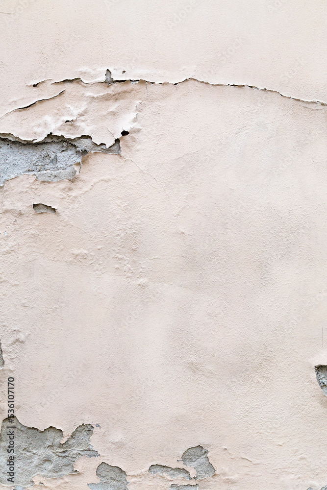 Abstract textured background graphic element. Peeling cream coloured paint on cracked concrete