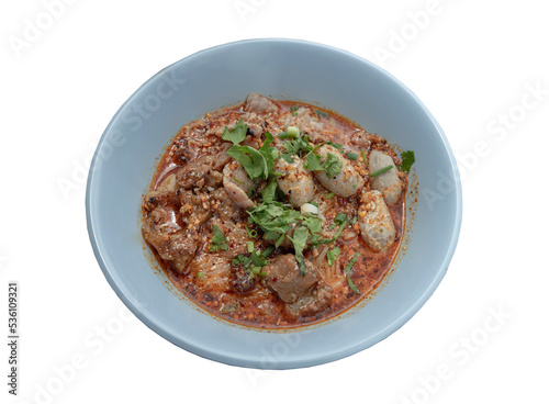 Spicy tom yum rice stick noodles (Thai spicy soup) with braised pork (stewed pork), fresh pork and pork balls sprinkled with coriander in bowl isolated on white background with clipping path. Selectiv