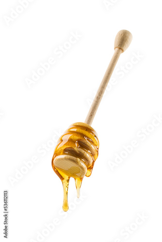 Honey dripping from wooden dipper, isolated on white.