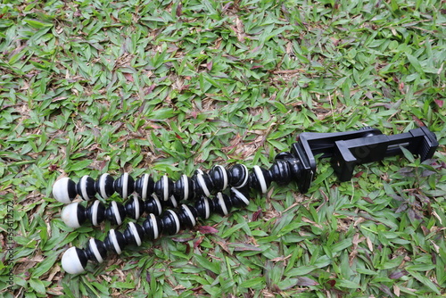 black flexible gorilla-pod for photo camera, with smartphone holder. 