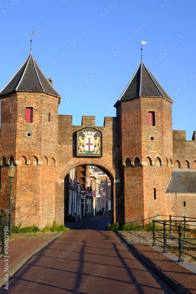Amersfoort, The Netherlands, August 8, 2022. The Koppelpoort medieval gate and city walls against a clear blue sky.
