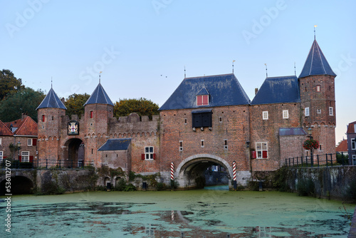Amersfoort, The Netherlands, August 22, 2022. The Koppelpoort medieval gate and city walls against a clear blue sky.