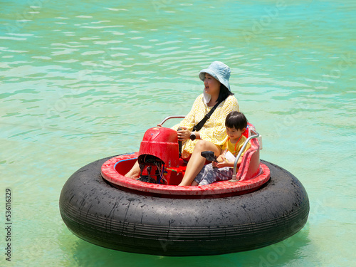 Mother and son having a fun in water park with Bumper boat