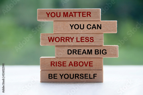 Inspirational words on wooden blocks - you matter, you can, worry less, dream big, rise above, be yourself. Inspirational and motivational concept