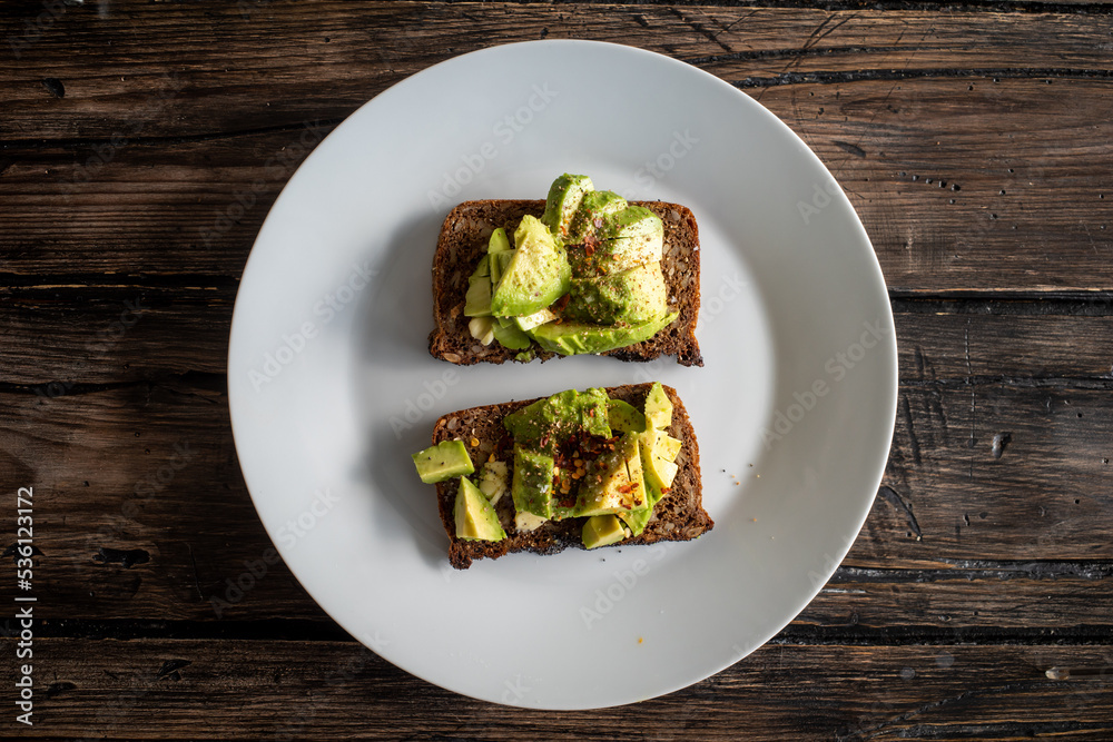 Crushed avocado with chili flakes on a pice of dark bread. Crushed avocado with chili flakes on a pice of dark bread.