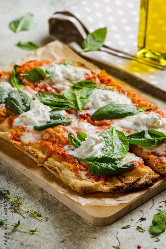 pinsa with strachatella, tomato sauce and spinach, rome pizza vertical