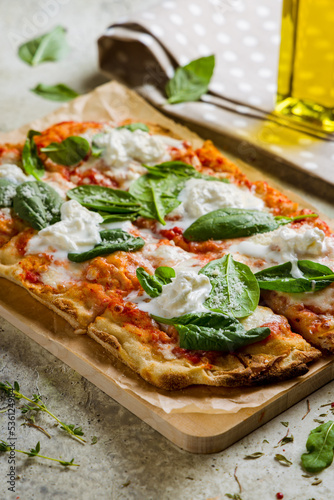 pinsa with strachatella, tomato sauce and spinach, rome pizza vertical