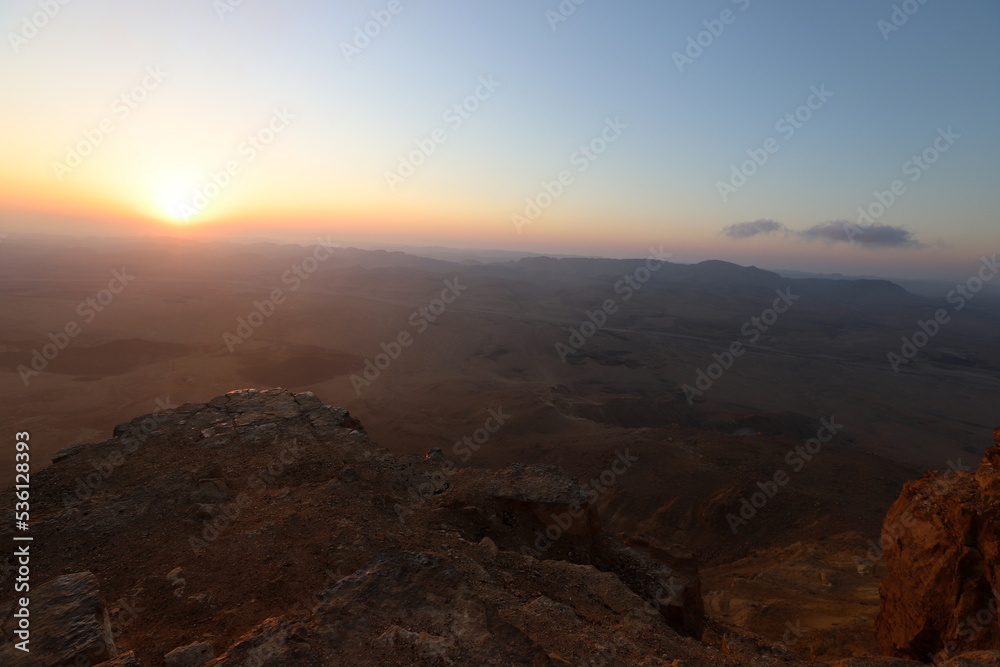 Sunrise on the shore of the Dead Sea in Israel. The sun rises from behind the mountains in Jordan.