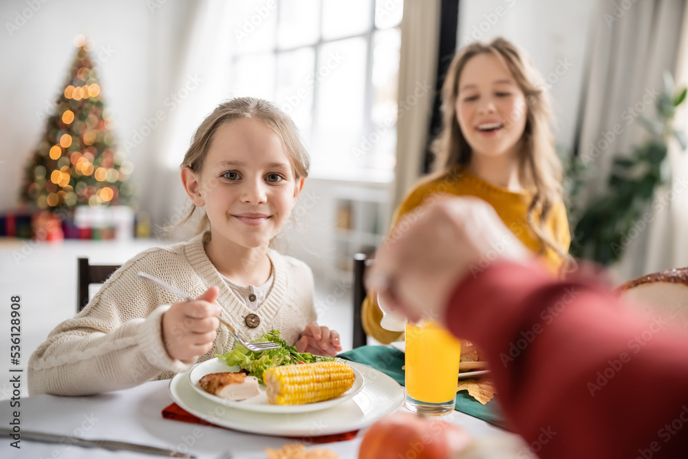 Smiling kid looking at camera near thanksgiving dinner with family at home Smiling kid looking at camera near thanksgiving dinner with family at home