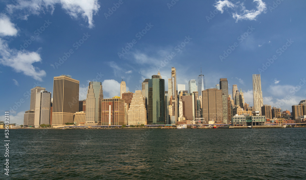 lower manhattan panorama from brooklyn side with bright cloudy sky