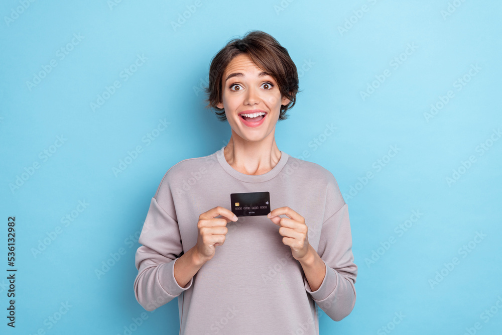 Photo of impressed cheerful woman bob hairdo wear gray pullover demonstrating bedit card online shopping isolated on blue color background Photo of impressed cheerful woman bob hairdo wear gray pullover demonstrating bedit card online shopping isolated on blue color background
