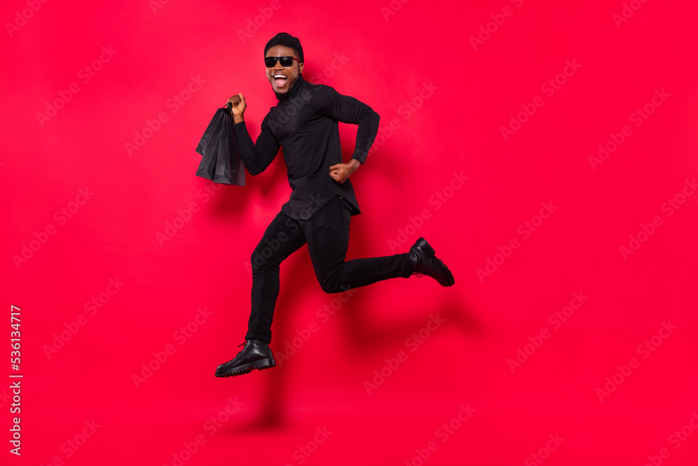 Full length body size view of handsome trendy cheerful guy jumping running shopping isolated over bright red color background