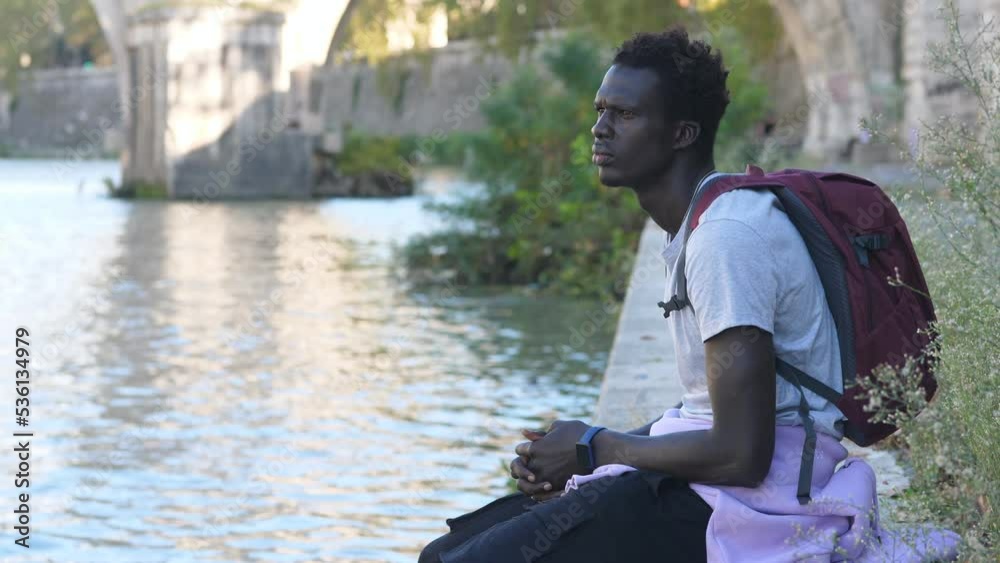 Thoughtful young african man contemplating the river, thinking Africa Thoughtful young african man contemplating the river, thinking Africa