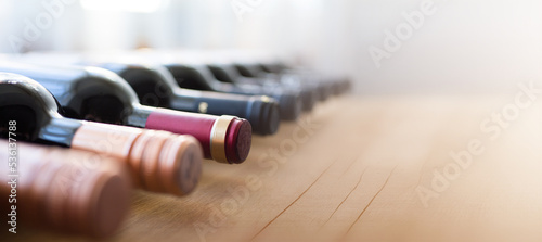 Bottles of red wine on a wooden shelf. banner background for winery, bar or shop