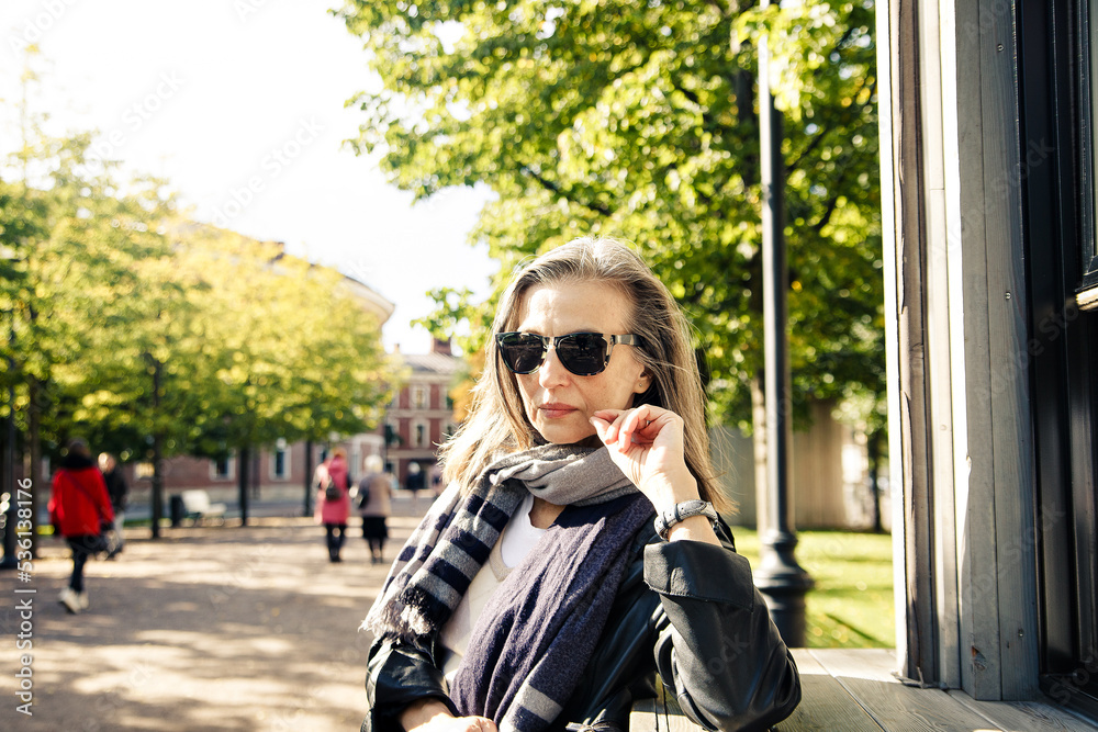 Fototapeta premium Portrait of a beautiful well-groomed elderly lady in an autumn park