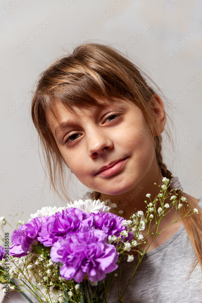 Beautiful 10-year-old girl with  bouquet of flowers in her hands