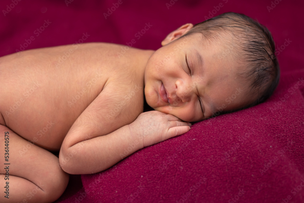 newly born baby laying on red velvet cloth with cute facial expression from different angle newly born baby laying on red velvet cloth with cute facial expression from different angle