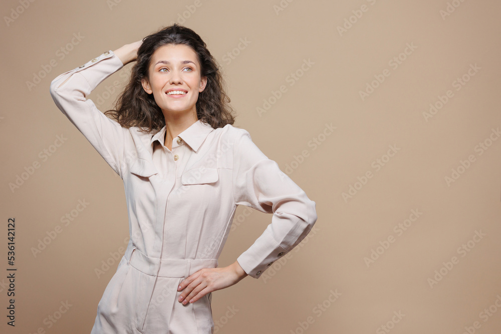 beautiful woman on a beige background touches her hair and smiles. posing for advertising, a place for text and ads. a confident European woman laughs, a successful business lady. a woman in light beautiful woman on a beige background touches her hair and smiles. posing for advertising, a place for text and ads. a confident European woman laughs, a successful business lady. a woman in light