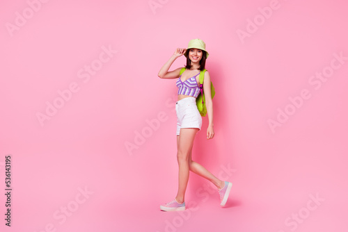 Full length photo of shiny sweet lady wear purple bra backpack walking empty space isolated pink color background