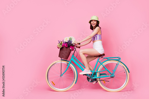 Full length photo of funny charming lady wear purple bra riding bicycle empty space isolated pink color background © deagreez