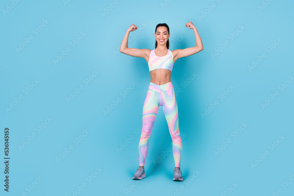 Photo of sporty bodybuilding coach demonstrate muscles wear rainbow print top leggings pants isolated blue color background