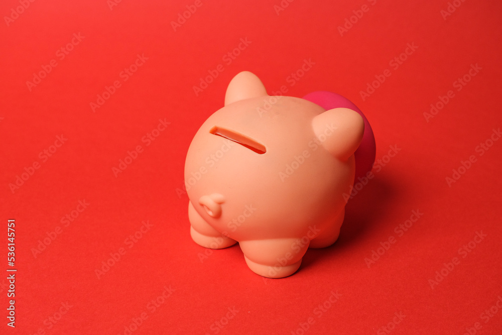 Piggy bank isolated on red background. Savings concept