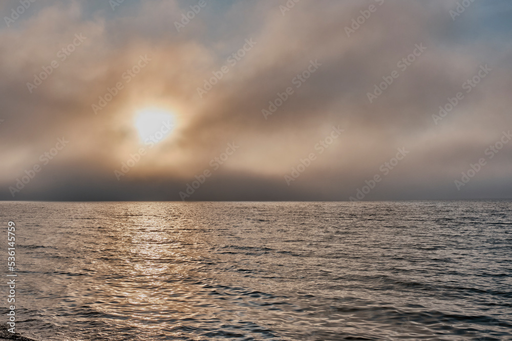 Sunset in fog on Lake Baikal, Buryatia, Russia. Dramatic sky.