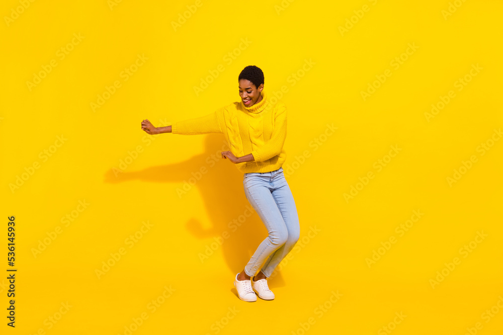 Full length body size view of attractive cheerful thin carefree girl dancing moving isolated over vivid yellow color background Full length body size view of attractive cheerful thin carefree girl dancing moving isolated over vivid yellow color background