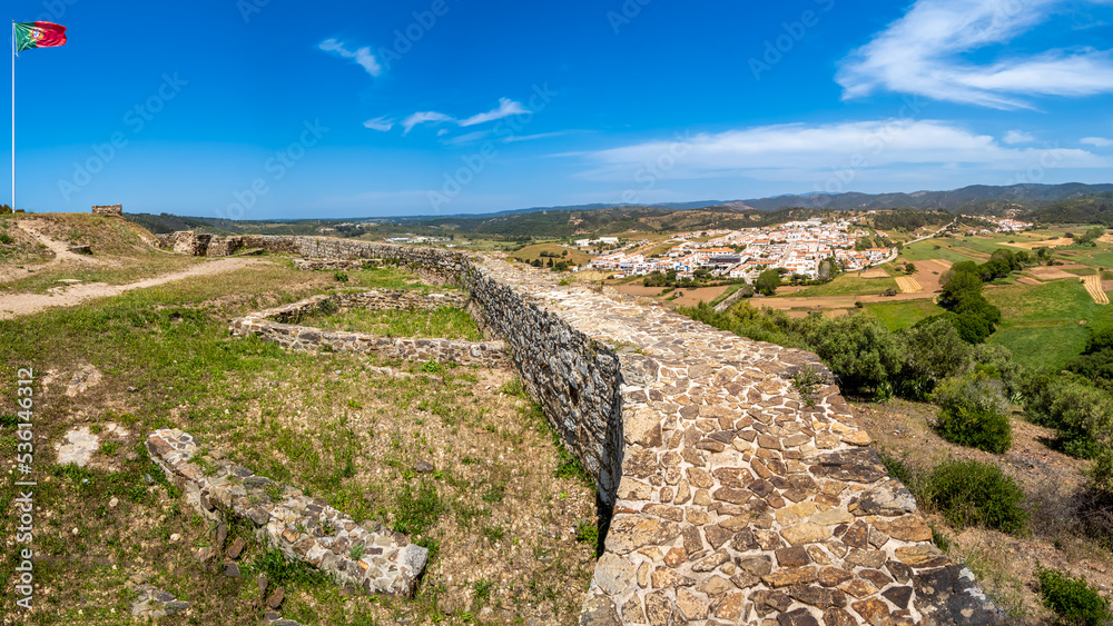 Panoramic view from the elevated ruins of the famous castle Castelo de Aljezur over rural farmland with the river Ribeira da Cerca to Aljezur village in the distance in the Algarve area of Portugal.