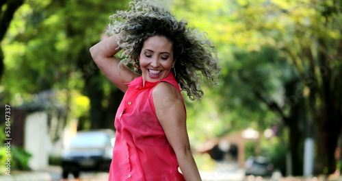 Happy hispanic woman dancing outside celebrating life