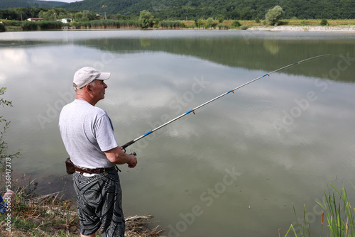Senior man fishing in lake in summer