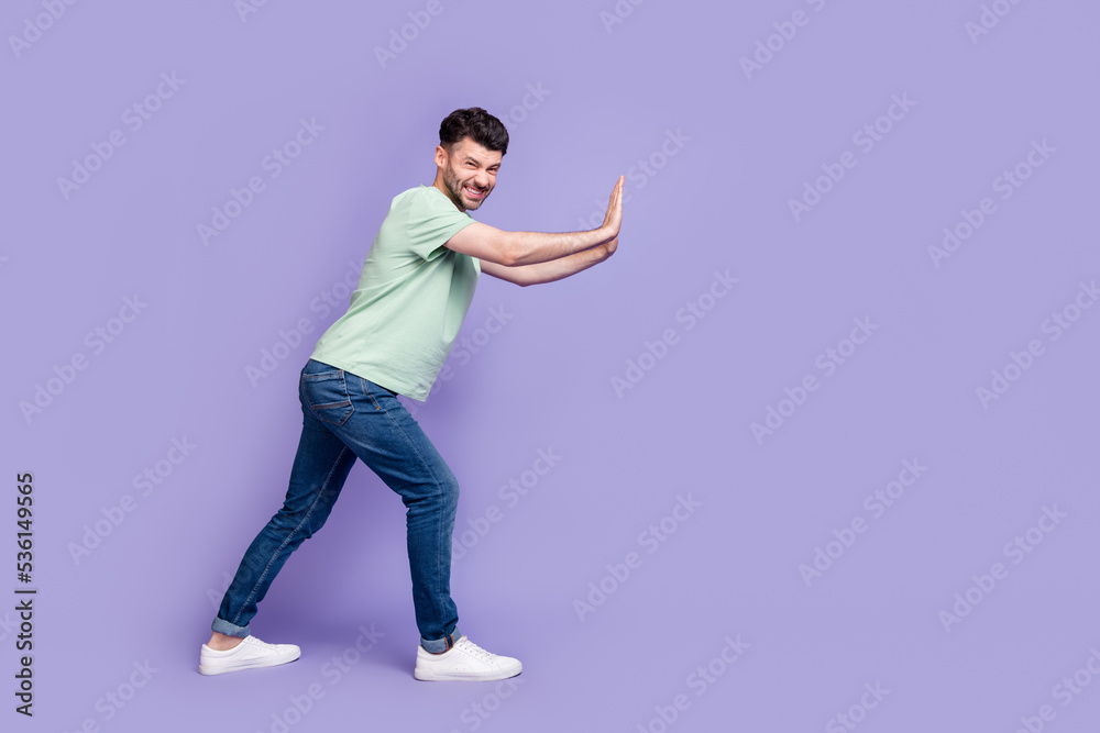 Full body photo of attractive young guy pushing hard copyspace difficult wear trendy gray clothes isolated on violet color background