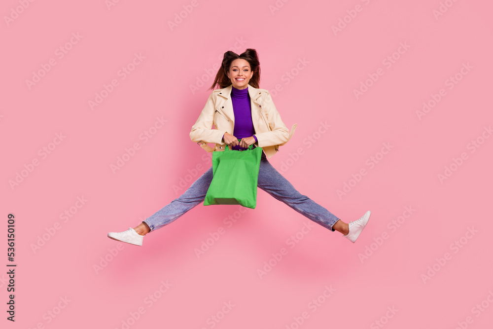 Full length photo of funky young lady jump hold bag wear casual cloth shoes isolated on pink color background