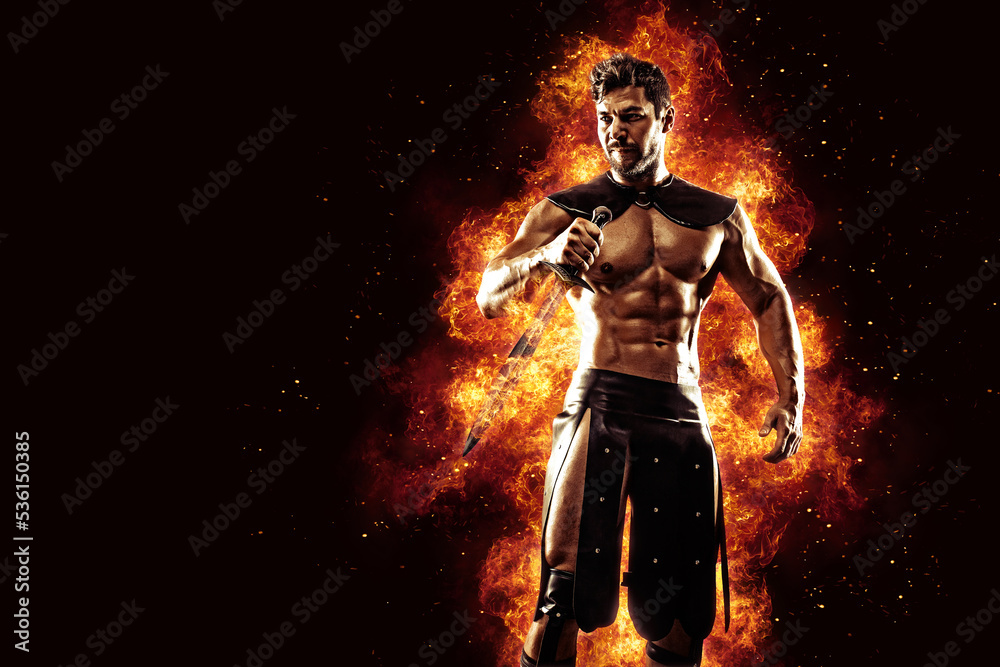 Sportive man in leather warrior costume with sword, fire on background Sportive man in leather warrior costume with sword, fire on background