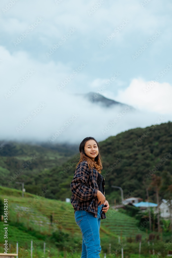 Naklejka premium Asian woman taking pictures, vacationing, relaxing, enjoying the air, enjoying the day off by traveling to nature. enjoy a vacation in nature.