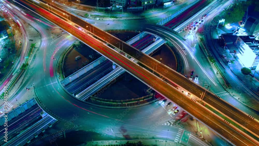 Hyperlapse time-lapse of car traffic transportation above circle roundabout road in Asian city, aerial view 4k cityscape of advanced innovation and financial technology.