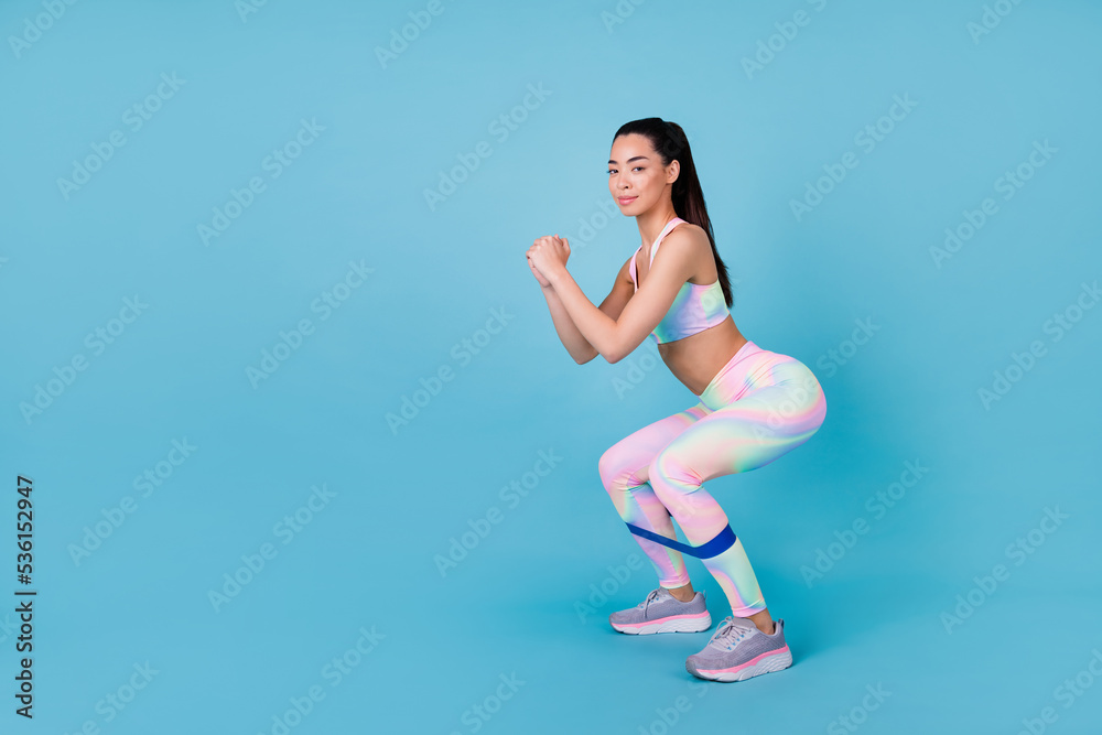 Photo of coach lady do pilates sit ups use fitness equipment wear rainbow print top leggings isolated blue color background