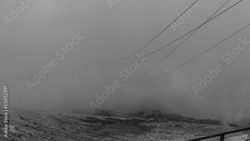 Cable car cables  coming out of the clouds in Austrian Alps glacier