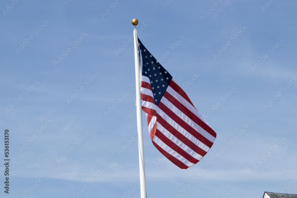 American flag waving in the wind with a blue sky American flag waving in the wind with a blue sky