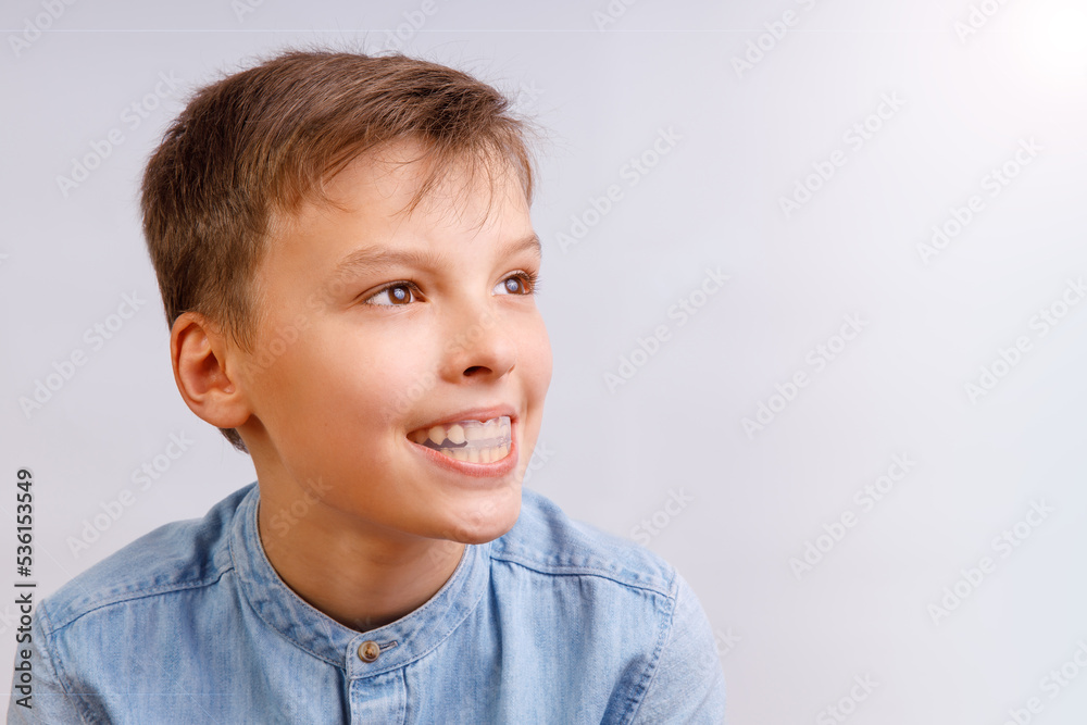 Boy is wearing orthodontic silicone trainer or night-guard case. Invisible braces helps of orthodontics problem. Close-up portrait. Mobile appliance for dental teeth correction. Boy is wearing orthodontic silicone trainer or night-guard case. Invisible braces helps of orthodontics problem. Close-up portrait. Mobile appliance for dental teeth correction.