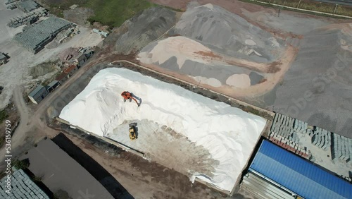 excavator and loader in sand warehouse