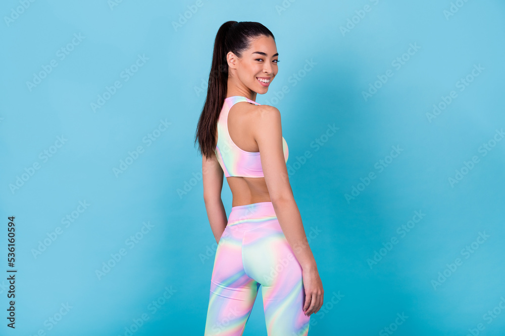Photo of attractive coach lady stand back rear behind wear stylish sport suit isolated on blue color background Photo of attractive coach lady stand back rear behind wear stylish sport suit isolated on blue color background