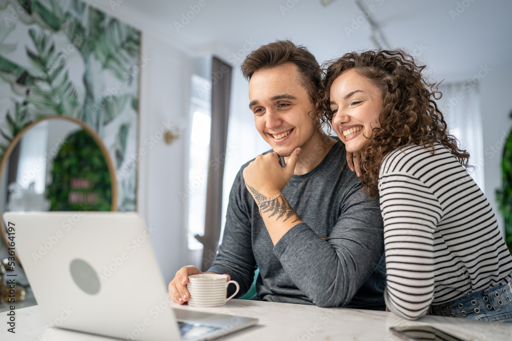 happy couple using laptop computer with cup of coffee morning routine happy couple using laptop computer with cup of coffee morning routine