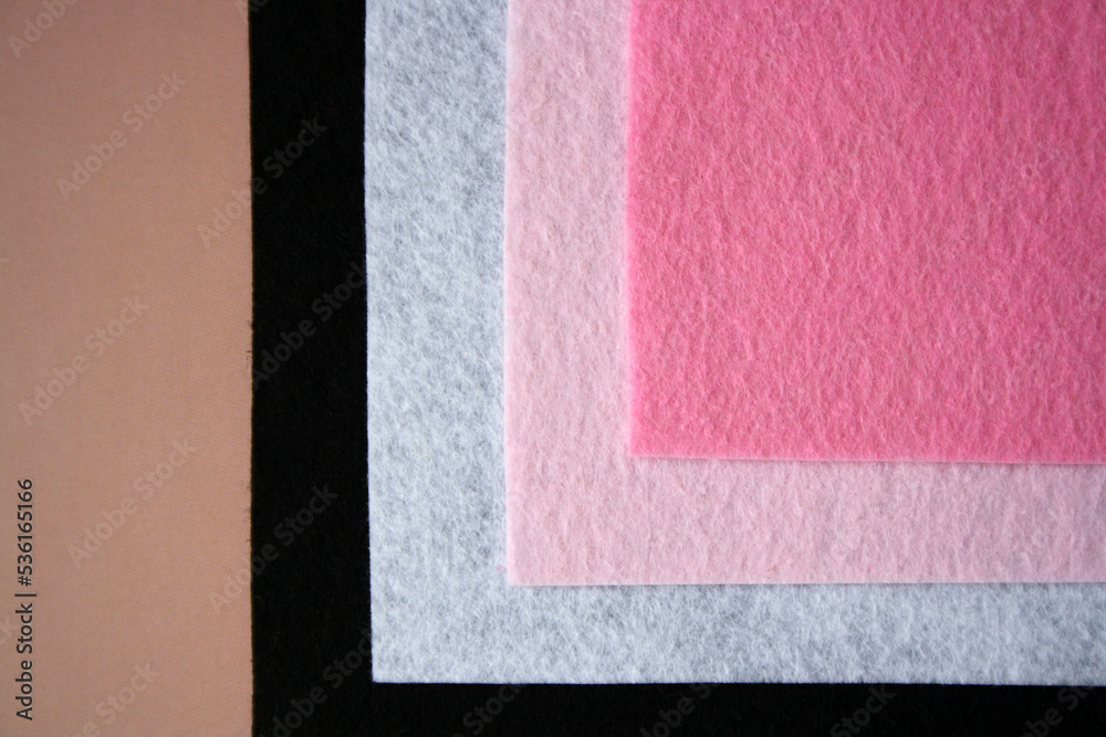 Fototapeta premium The background is made of black, white and pink felt. Examples of felt fabric.