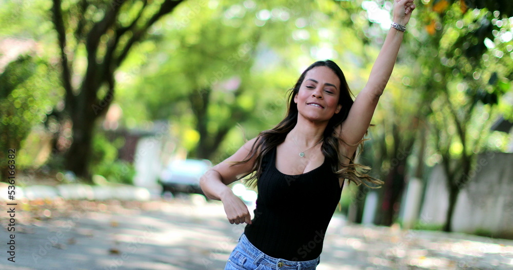 Happy woman celebrating jumping with joy outside feeling joy achievement Happy woman celebrating jumping with joy outside feeling joy achievement