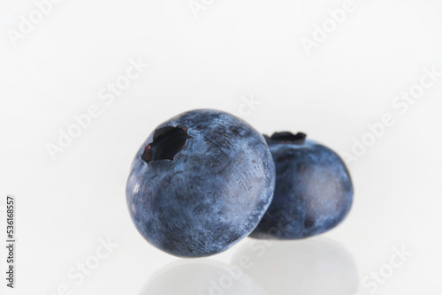 Close-up. Two fragrant ripe blueberries isolated on white background. Vitamins, antioxidants, cooking. Recipe book, food blog. There are no people in the photo. Minimalism.